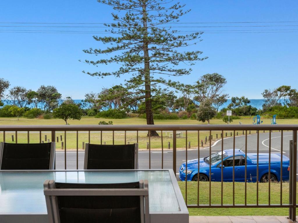 a blue car parked on a road with a fence at Tradewinds 1 on Kingscliff Beach in Kingscliff