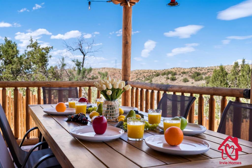 una mesa de madera con fruta y zumo en una terraza en Hillside Haven Retreat - A Placitas Irvie Home en Santa Ana Pueblo