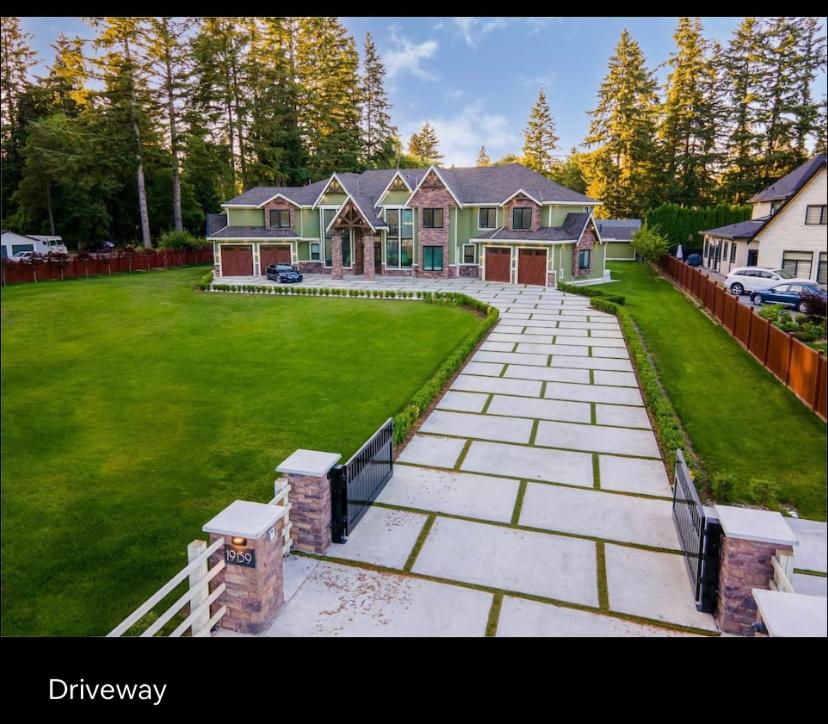 a large house with a driveway in a yard at Big and Luxury House in Surrey