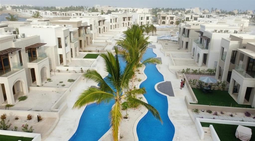 ein Luftblick auf ein Resort mit einem Pool und Palmen in der Unterkunft Hawana Salalah - Riviera NEW in Salalah