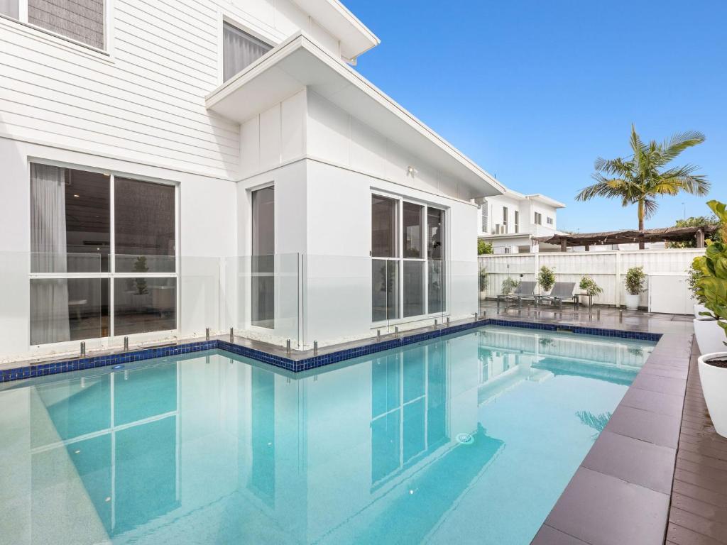 a swimming pool in front of a house at Sunrise Mansion with Pool in Kingscliff