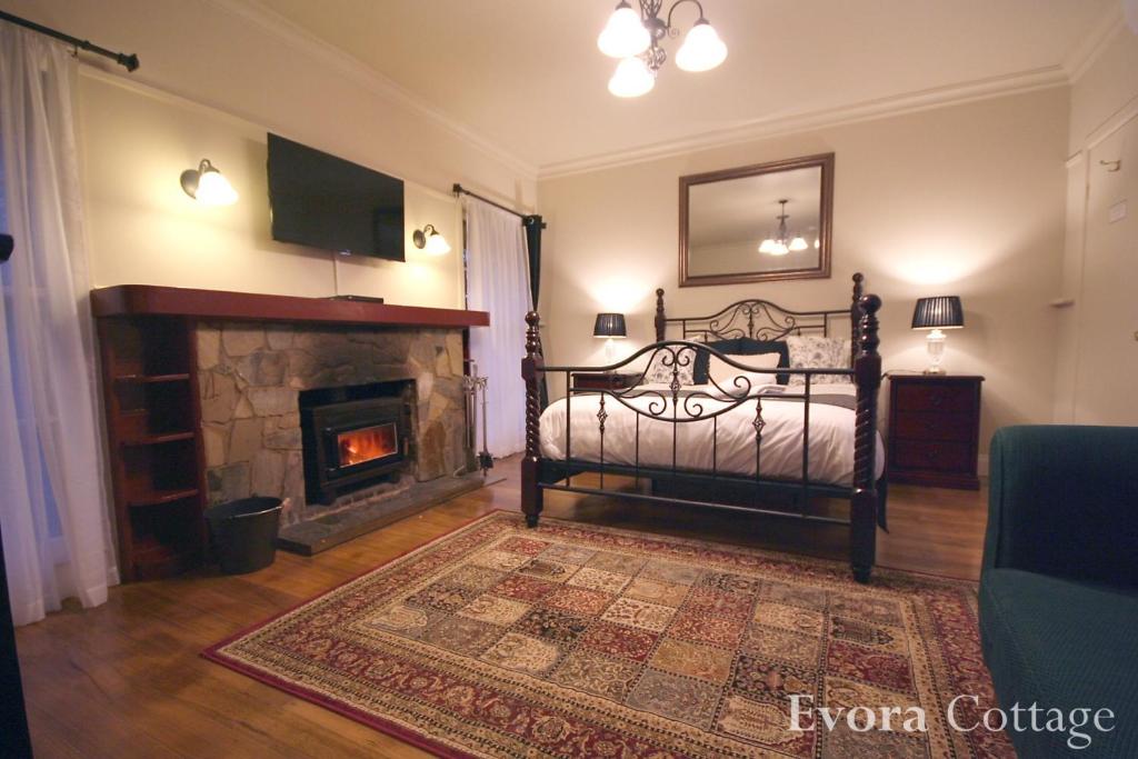 um quarto com uma cama e uma lareira em Tudor Cottages em Mount Dandenong
