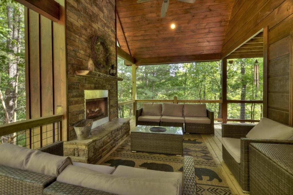 una veranda protetta con divani e un camino di Papa Bear Lodge a Blue Ridge