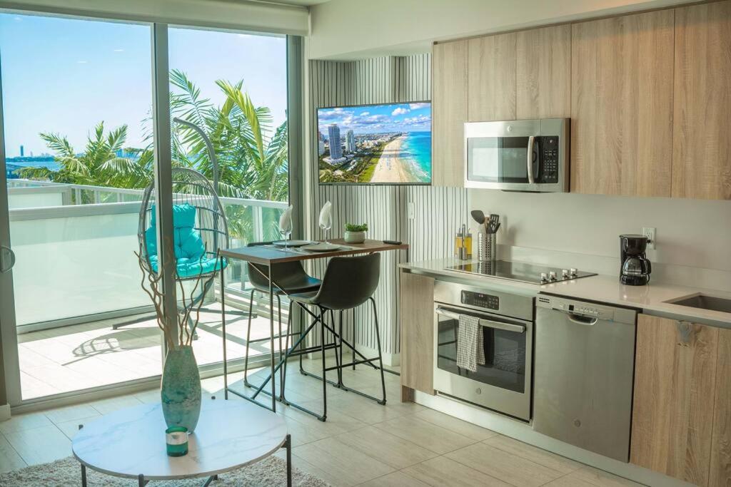 a kitchen with a table and a kitchen with a balcony at Luxury Oceanview Studio at Miami Design District in Miami