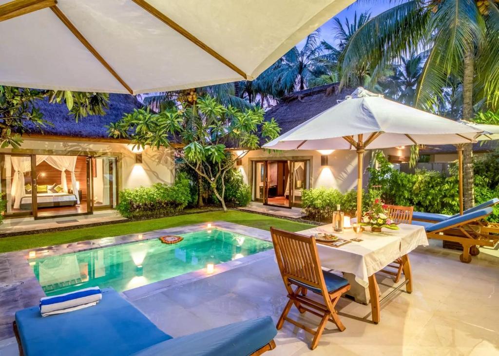 Casa con piscina con mesa y sombrillas en Villa Sasoon, 100 mt to Beach en Candidasa