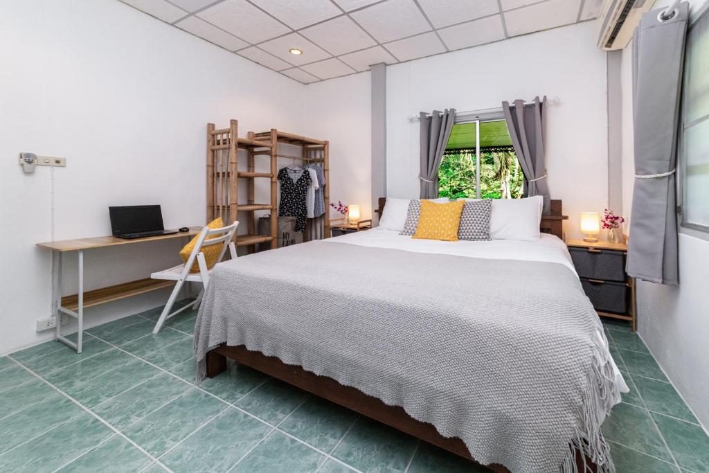 - une chambre avec un grand lit et un bureau dans l'établissement Garden Home 1, à Haad Yao