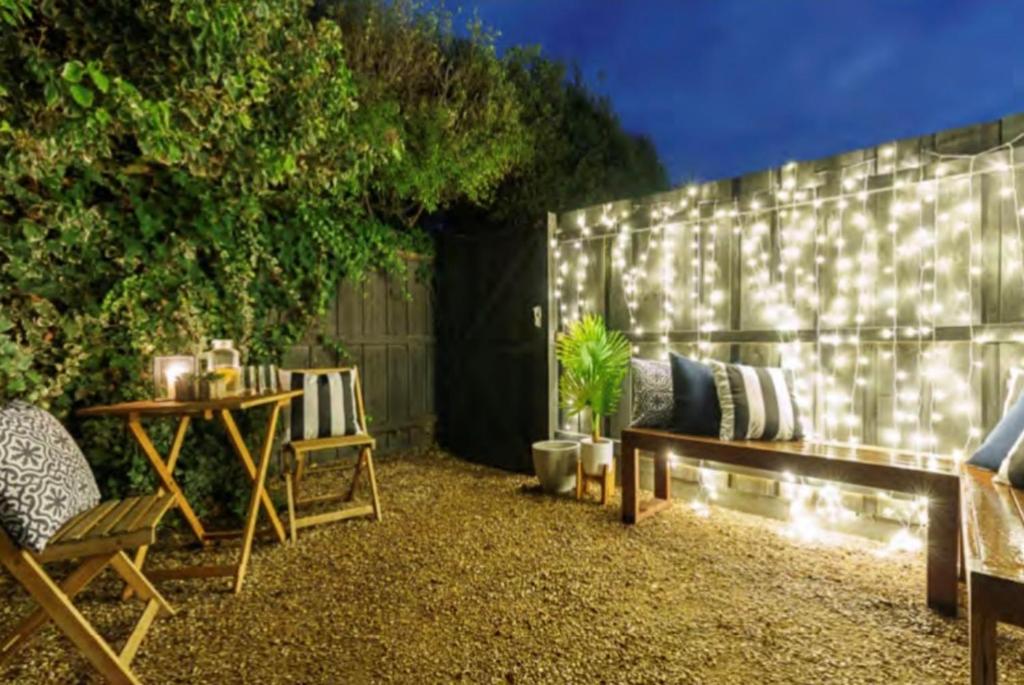 un jardín con banco, mesa y valla en Quite, quaint & private guesthouse, sleeps 6, en Melbourne