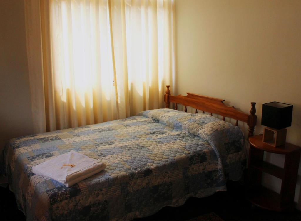 a bedroom with a bed and a window with curtains at Schmidt Hostal in Pozuzo