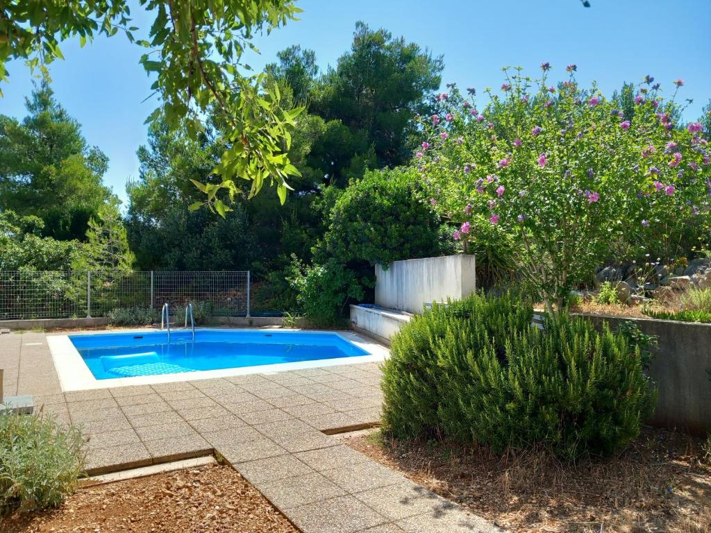 a swimming pool in a garden with flowers at 25 King's Landing in Supetar in Supetar