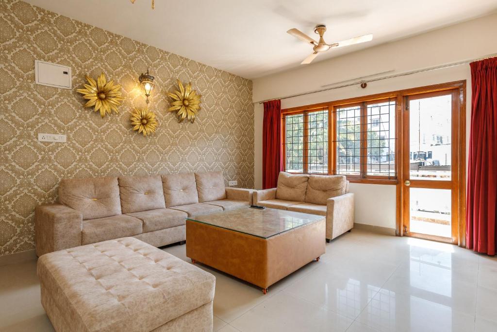 uma sala de estar com um sofá e uma mesa em Elegant Apartment by JadeCaps Wifi Private balcony em Bangalore