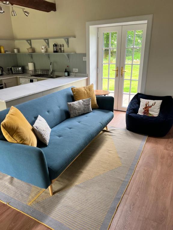 a blue couch sitting in a living room at Blairbeg Cottage in Blairgowrie