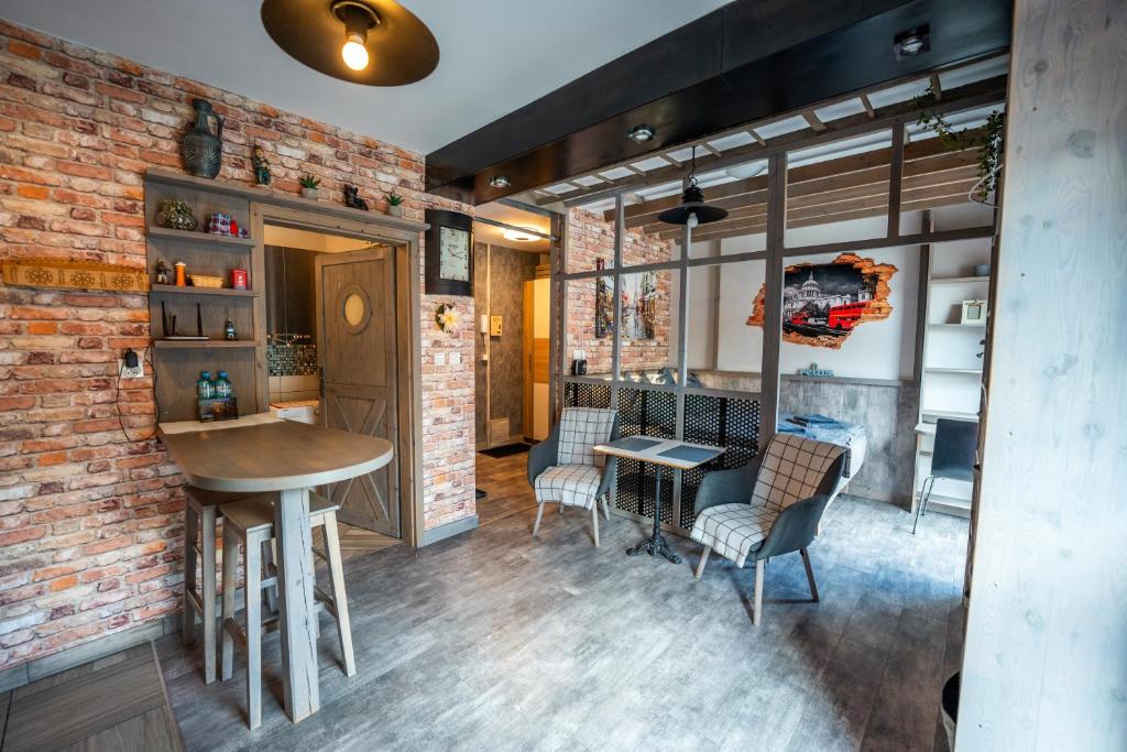 a kitchen with a table and chairs and a brick wall at Olivia apartament przy deptaku in Szczawno-Zdrój