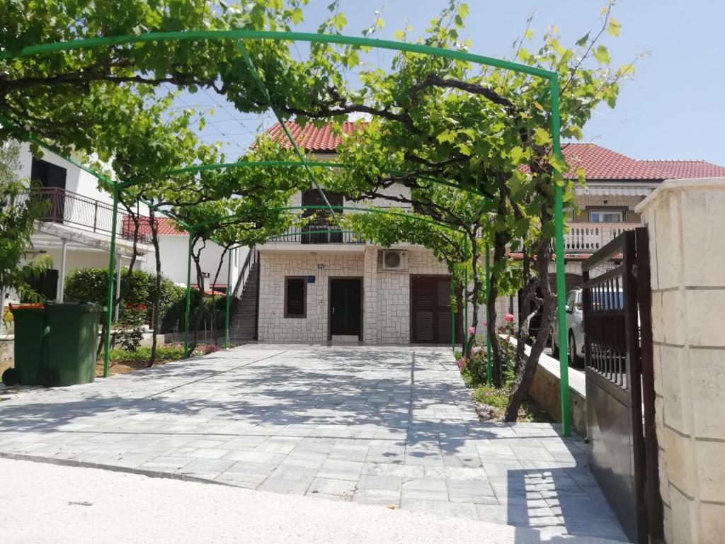 a green archway in front of a house at Apartments Samodol in Vodice