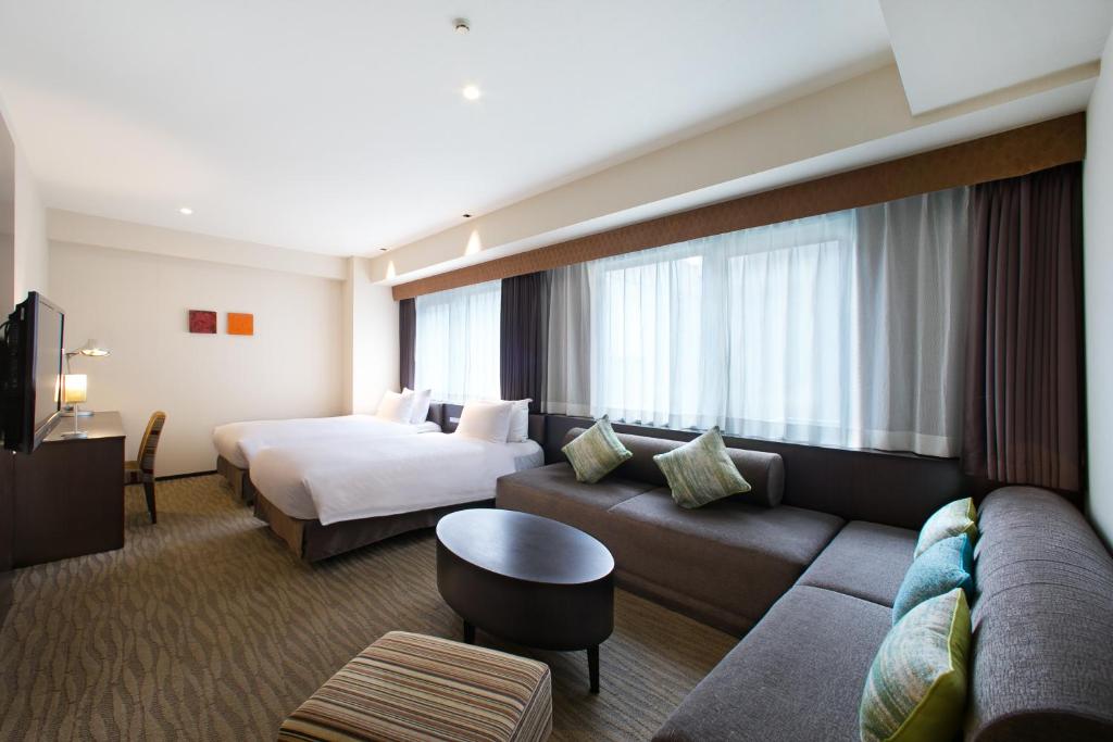 a hotel room with a bed and a couch at Holiday Inn Osaka Namba by IHG in Osaka