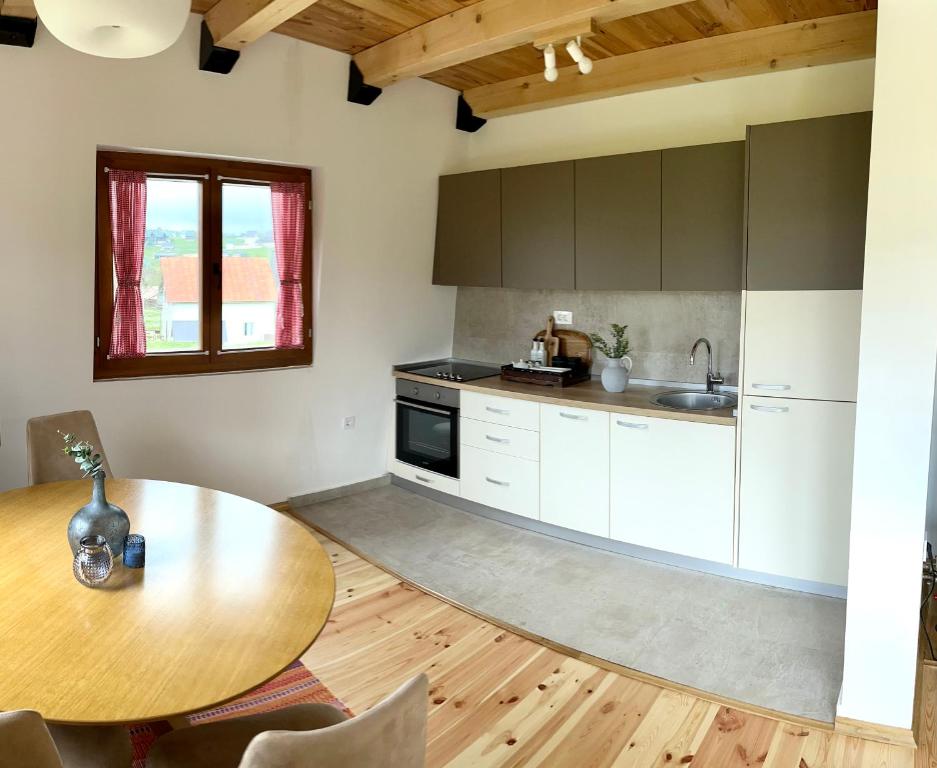 a kitchen with a wooden table and a wooden floor at Divine House in Žabljak