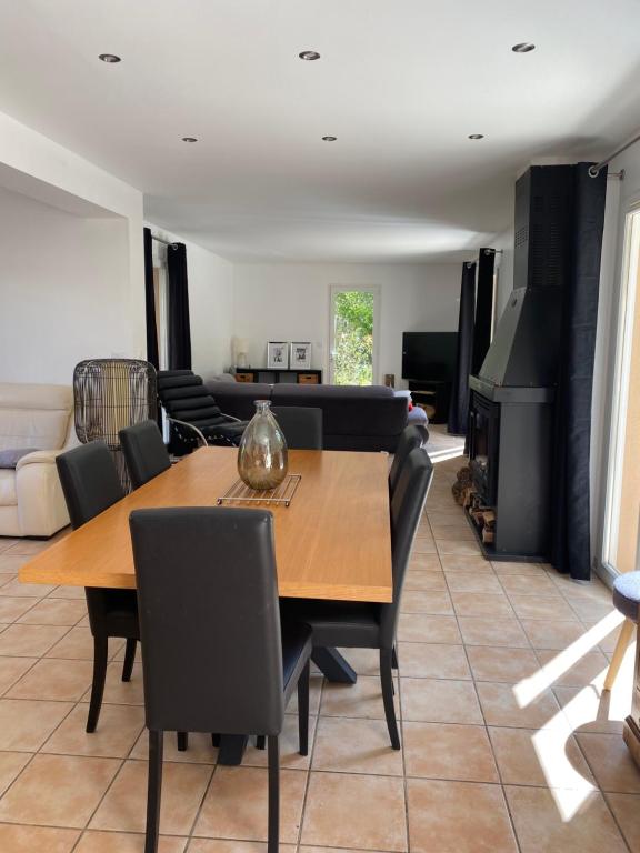 un salon avec une table et des chaises en bois dans l'établissement Villa Giens - Plage à pied -9 couchages, à Hyères