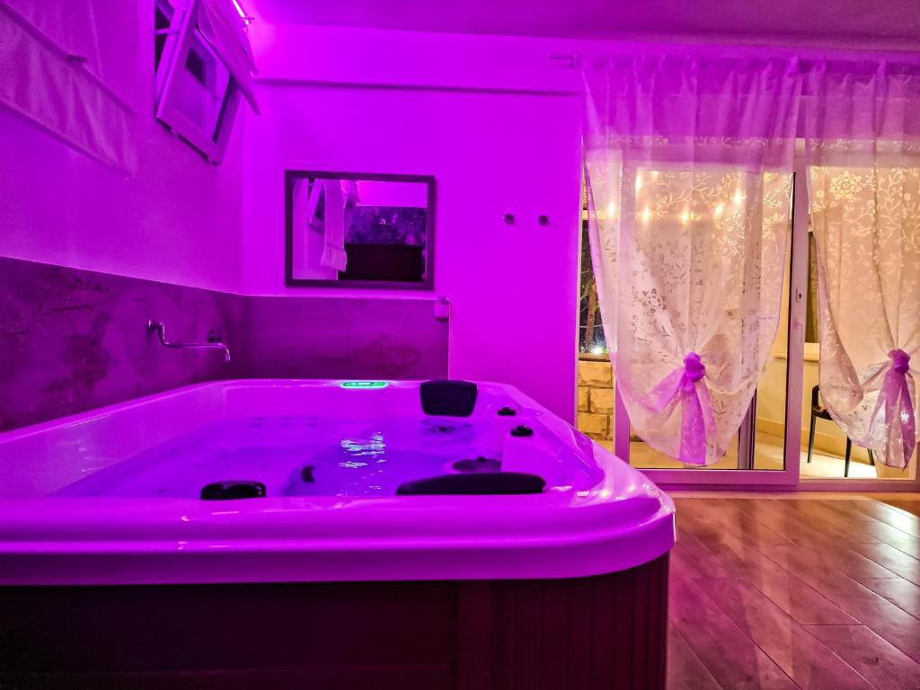 Habitación con baño rosa con bañera. en Residence Del Tellaro en Noto Marina