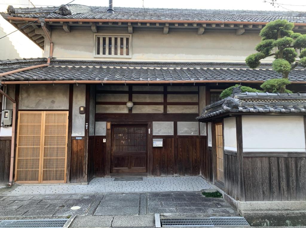 una entrada a un edificio con puerta de madera en Old Japanese House en Tondabayashi