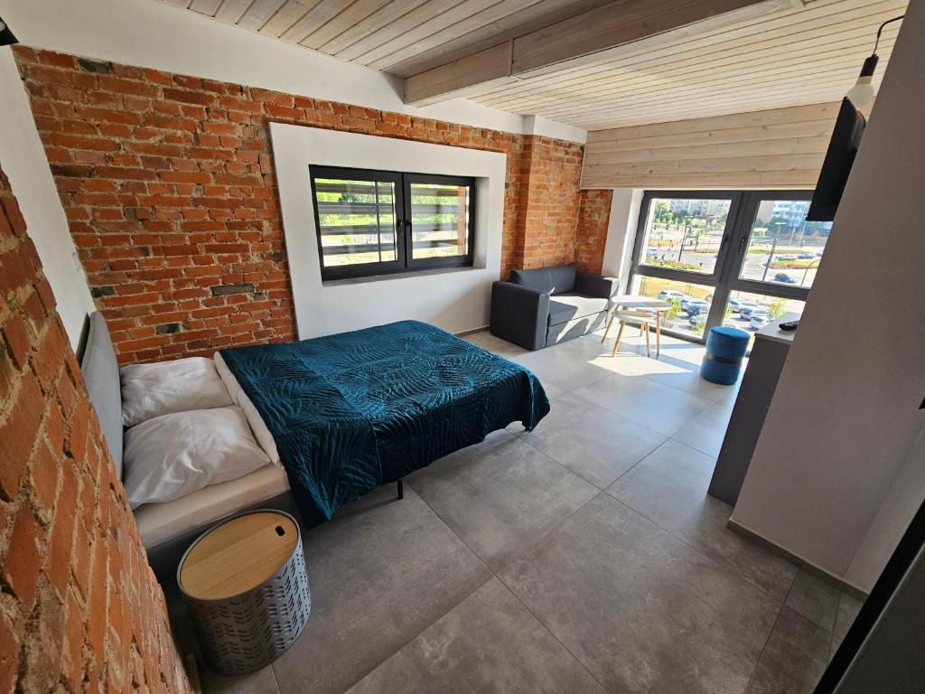 a bedroom with a bed and a brick wall at Karpacka 8 in Bydgoszcz