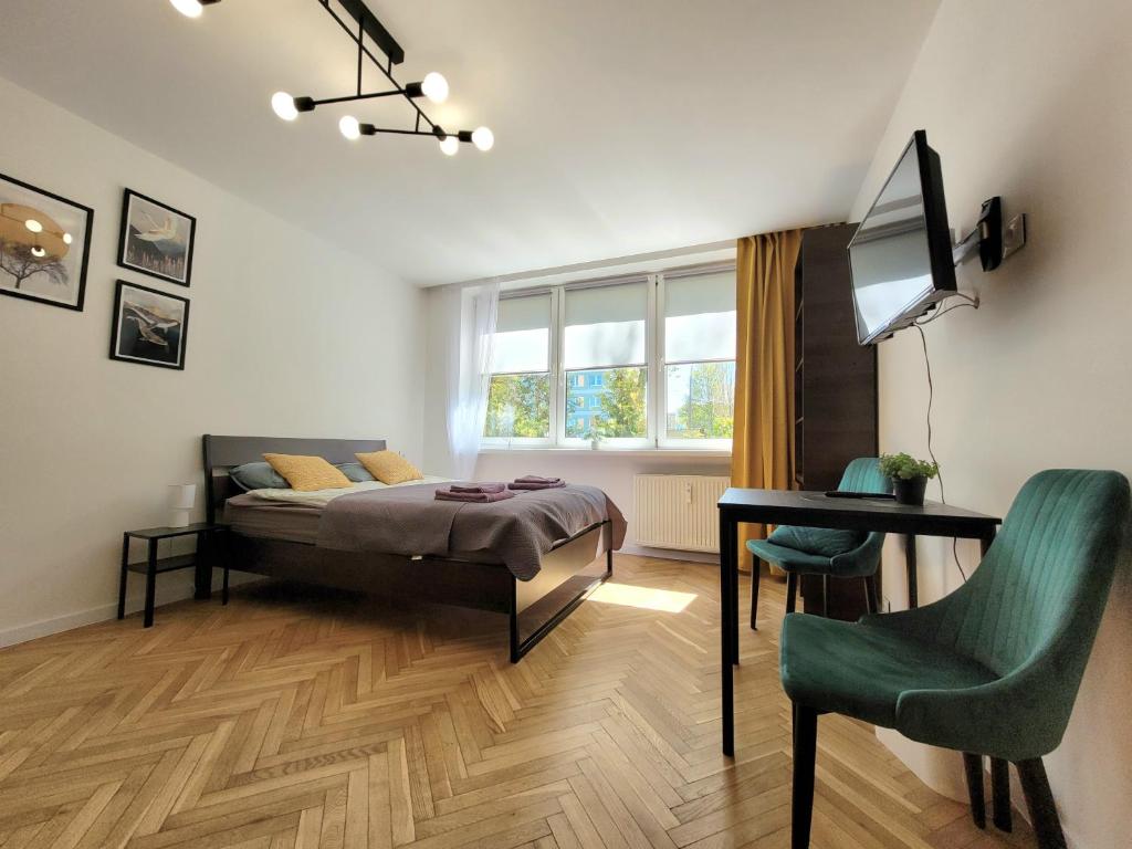 a bedroom with a bed and a desk and a chair at Apartament 21 in Gdynia