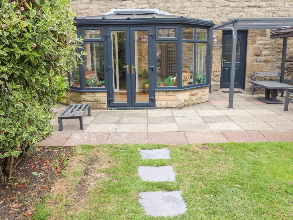 a greenhouse with a bench in a yard at Muscle Shoals in Seahouses