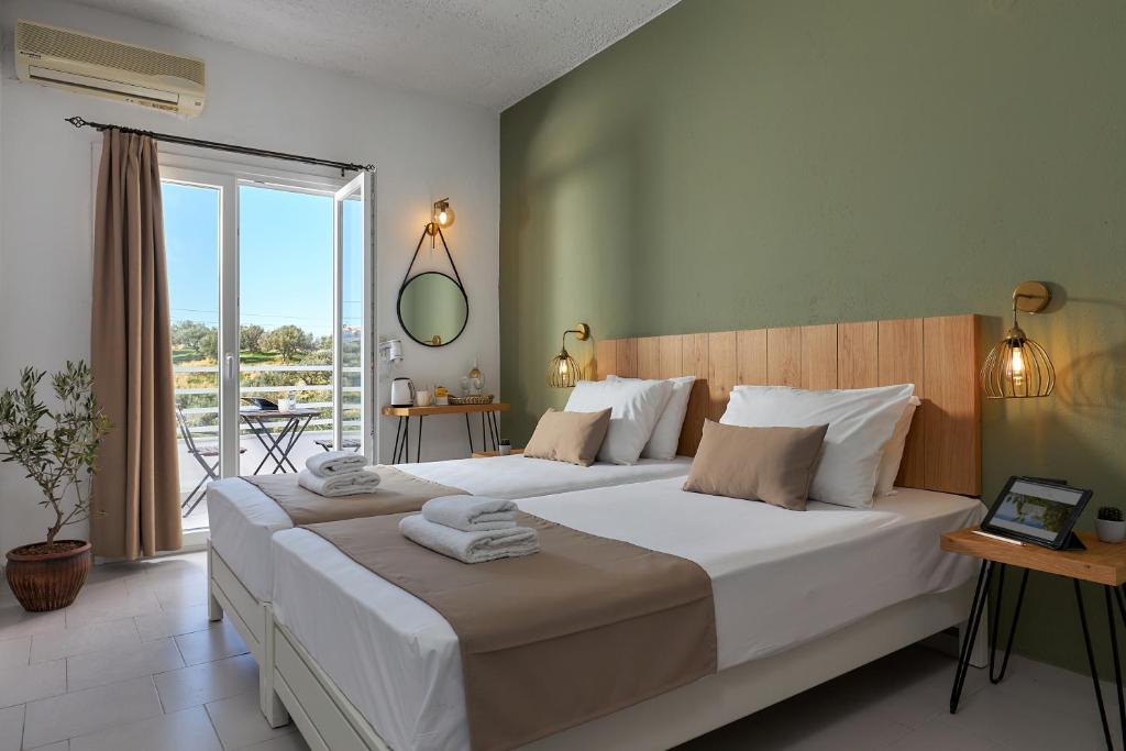 1 dormitorio con 1 cama grande y balcón en Charm Hotel, Hersonissos, en Hersonissos