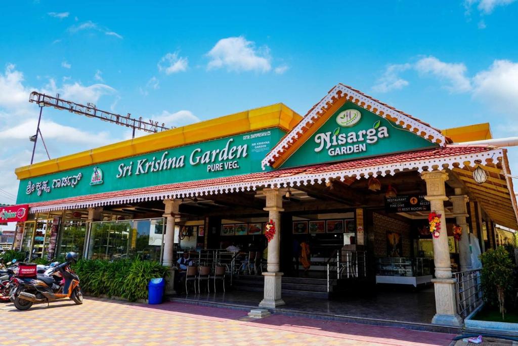 a restaurant with a motorcycle parked in front of it at Sri Krishna Inn - Kempegowda Airport Bangalore in Bangalore