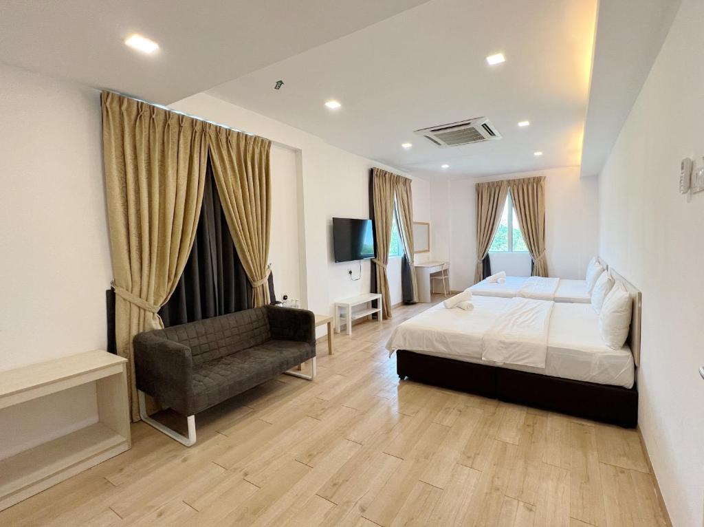 een slaapkamer met een bed en een bank erin bij Vvip Hotel in Hutan Melintang