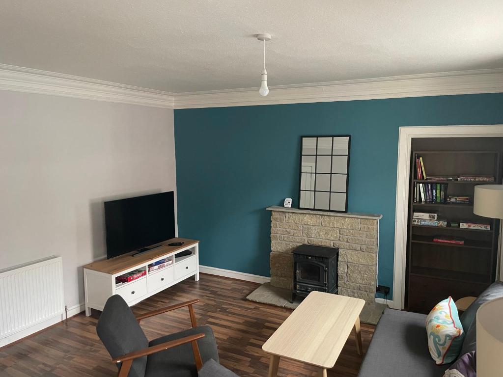 本提斯埃蘭的住宿－Lovely 2 bedroom condo in Burntisland, Fife，客厅设有蓝色的墙壁和壁炉。