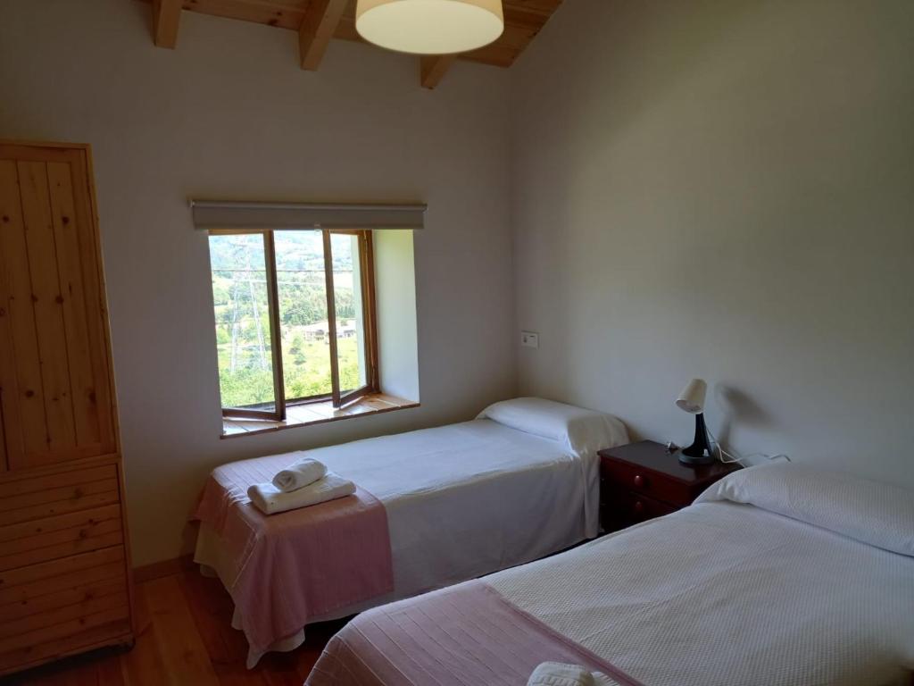 a bedroom with two beds and a window at Ca Bastiana in La Piñera