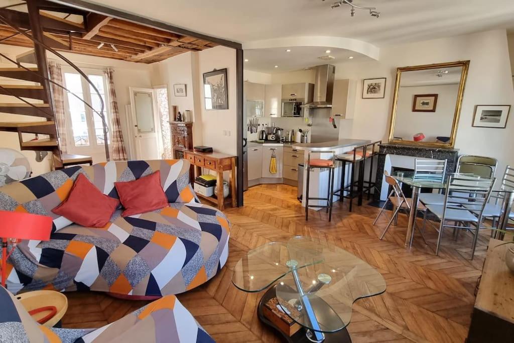 un salon avec un canapé et une table et une cuisine dans l'établissement Superbe logement au centre de Paris, à Paris