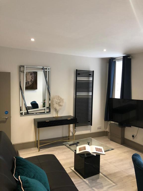 a living room with a couch and a mirror at Just the tonic in Nottingham