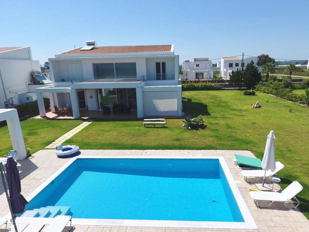 une grande piscine en face d'une maison dans l'établissement Πολυτελής Βίλα στην άκρη της θάλασσας, à Kastro Kyllini