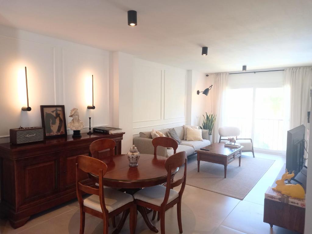 sala de estar con mesa y sofá en Apartamento Los Álamos Totalmente reformado Junio 2023 en Torremolinos