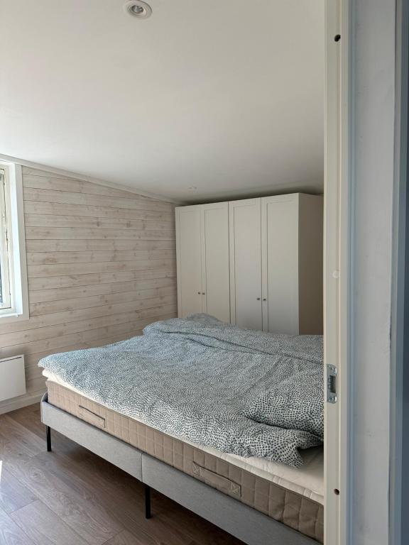 um quarto com uma cama e armários brancos em Apartment Ormestad em Uddevalla