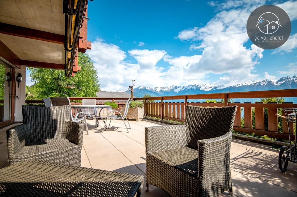 eine Terrasse mit Stühlen und einem Tisch mit Bergen im Hintergrund in der Unterkunft Carving Residence in Ovronnaz