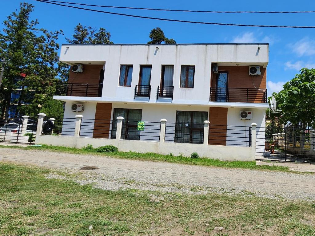a large white building on the side of a road at Rio cottage apartment in Ureki