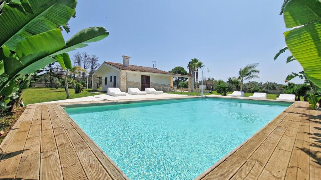 una piscina con sedie e una casa di Villa Paradiso by Salento Affitti a Marina di Mancaversa