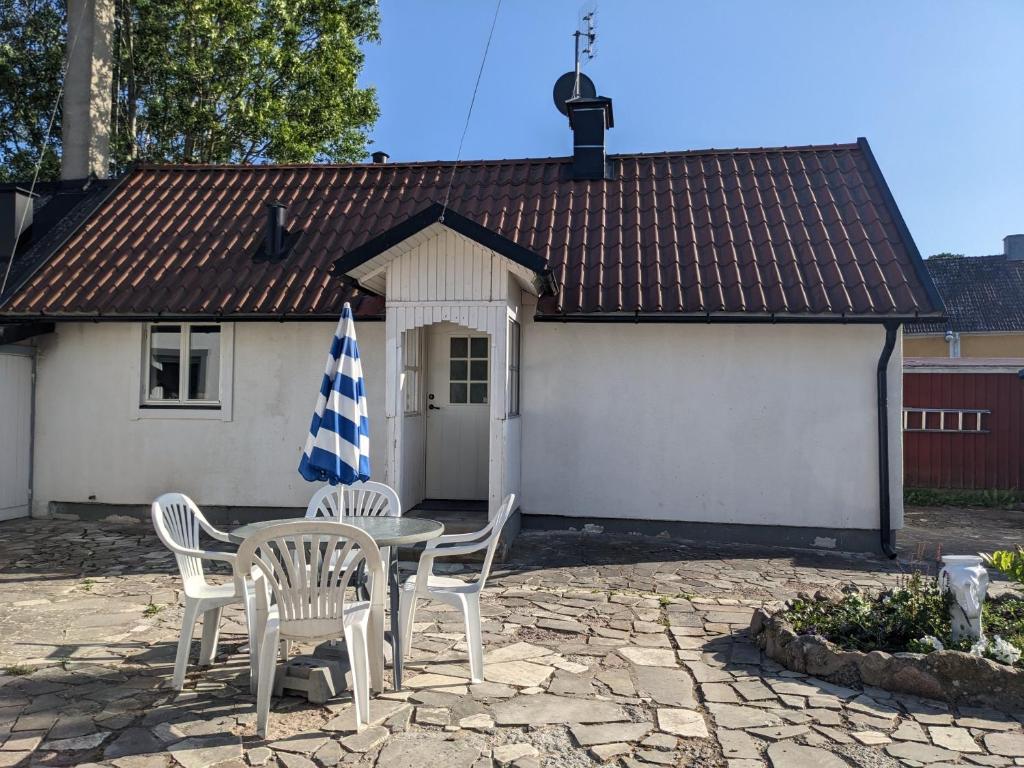 einen Tisch mit Stühlen und einen Regenschirm vor einem Haus in der Unterkunft Casa Bianca in Vadstena