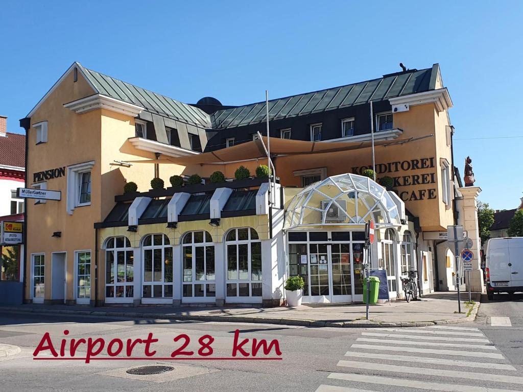 un grand bâtiment dans une rue avec un magasin dans l'établissement Pension Müller Gartner, à Groß-Enzersdorf