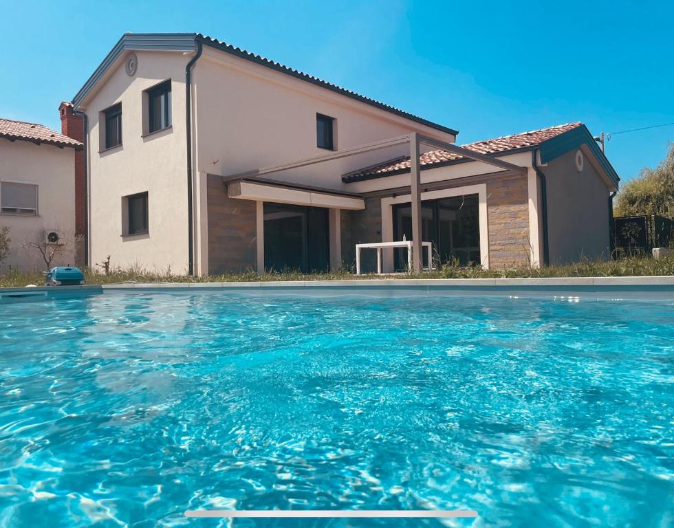 a house with a swimming pool in front of a house at Paradise villa with private swimming pool in Koper
