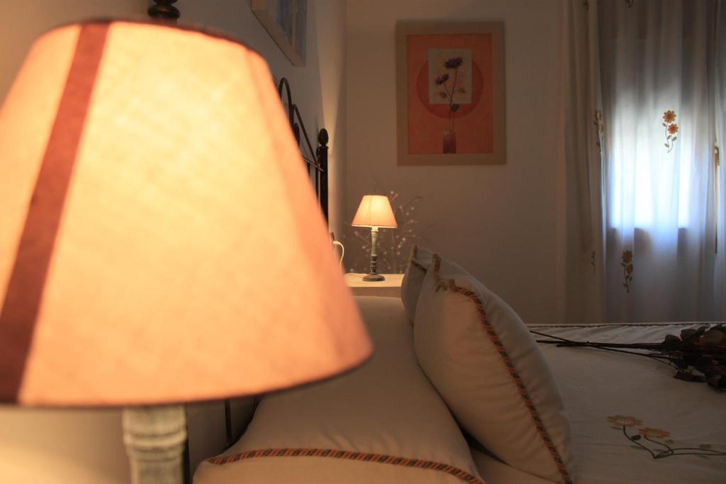 a lamp sitting next to a bed in a bedroom at Casa Mirasierra in Mota del Cuervo