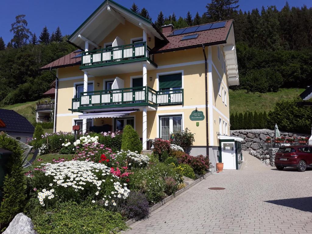 una casa con balcón y flores delante de ella en LANDHAUS JASMIN ausgezeichnet mit 4 Kristallen - FW Zinkenblick, en Bad Mitterndorf