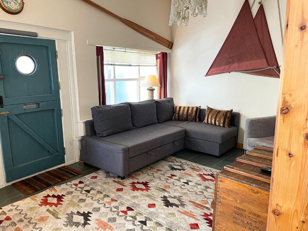 a living room with a gray couch and a green door at Zion Place in Dartmouth