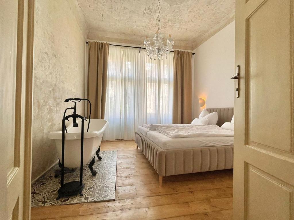 een slaapkamer met een bed en een bad en een bed en een raam bij Apartmá Adina 1905 in Karlsbad