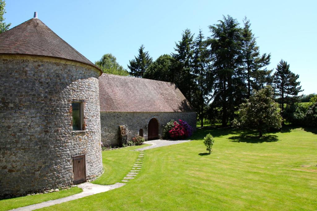 a large stone building with a grass yard at Le Colombier de Hanches - Teritoria in Hanches