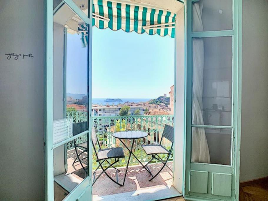 Cette chambre dispose d'un balcon avec une table et une porte en verre. dans l'établissement 20 LACROI - Superbe appartement 2 chambres avec vue mer centre Cannes, à Cannes