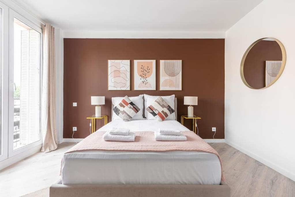 une chambre avec un grand lit et un miroir dans l'établissement Studio lumineux Paris Est - Serurier, à Paris