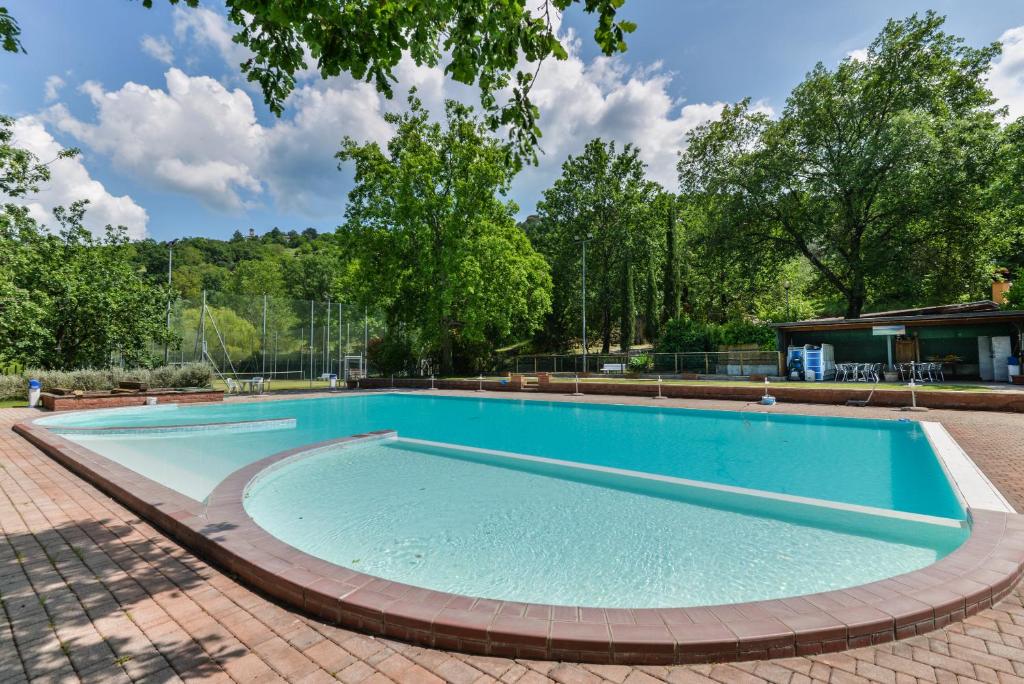 a large swimming pool in a brick yard at Casa Rustica singola con piscina immersa nella natura in parco privato in Castel del Piano
