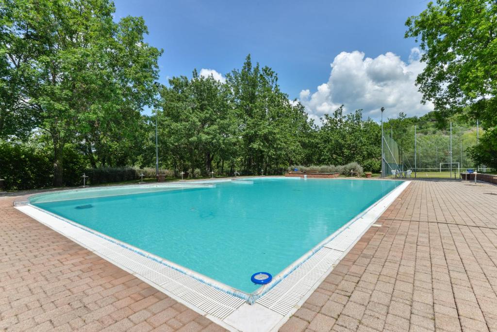 a large swimming pool with blue water at 3 Charming Private Home with Pool, BBQ, Wi-Fi & Free Parking in Castel del Piano